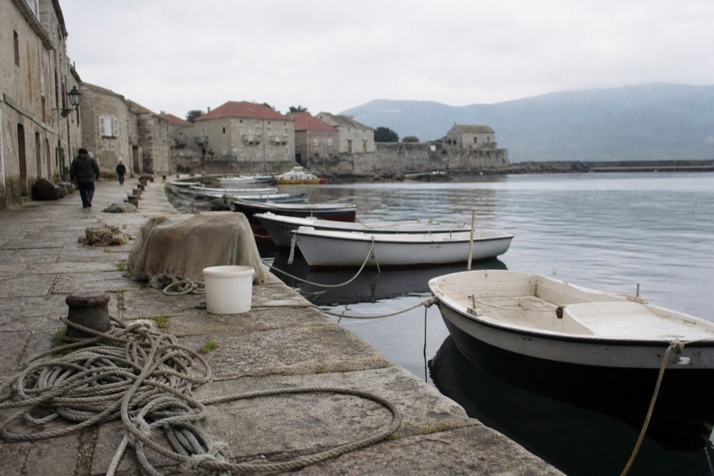 Lakeside promenade with boats moored along the shore, no text, no logos, no people