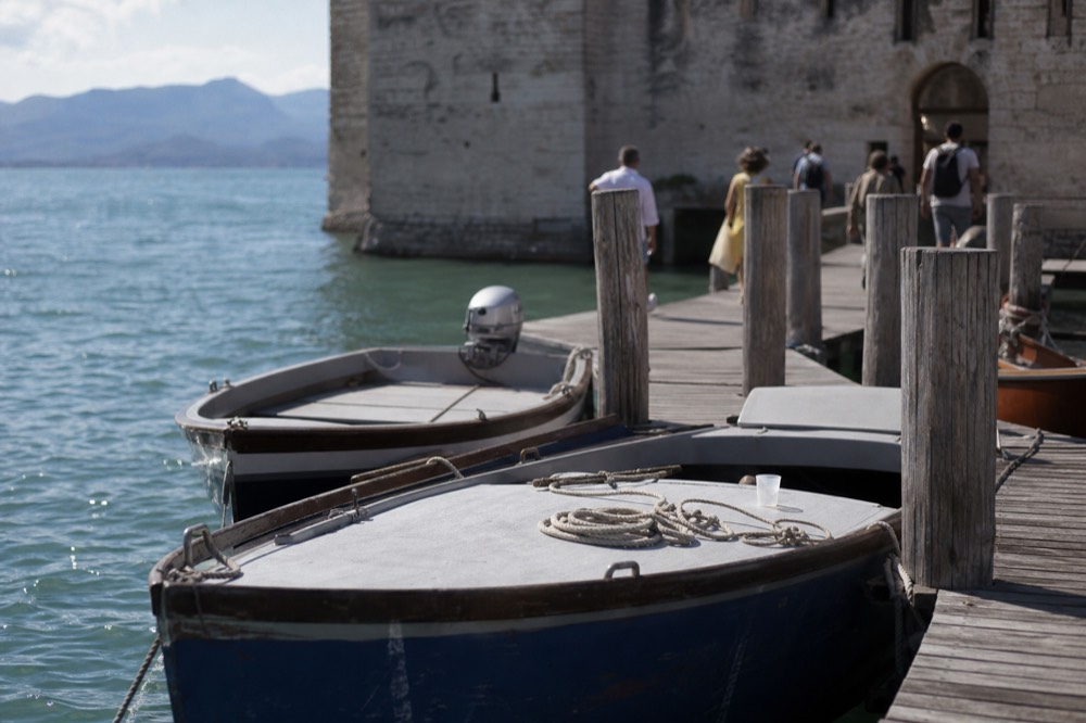 Ferry pontoon and lake water at Peschiera del Garda with boats moored, no text, no logos, no people