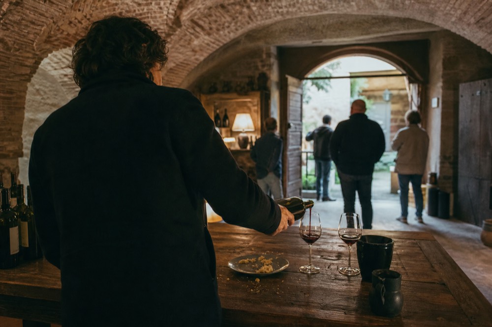 A sommelier pouring Amarone at a tasting table in a villa cellar, no text, no logos, no people