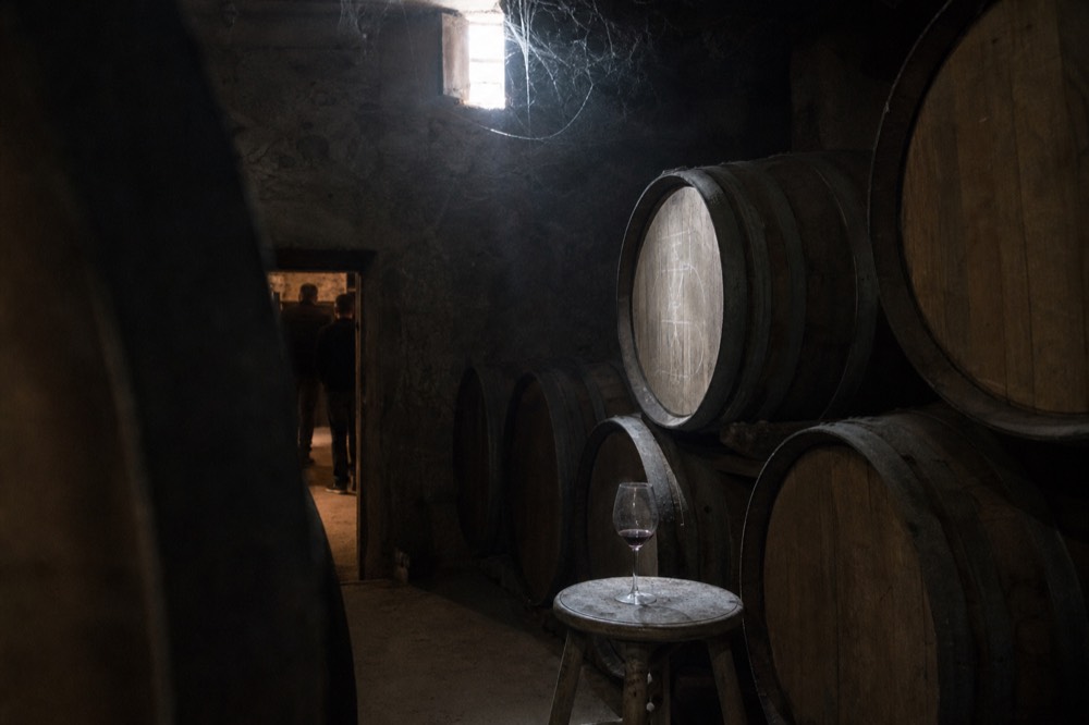 Oak barrels resting in a dim Valpolicella cellar, no text, no logos, no people